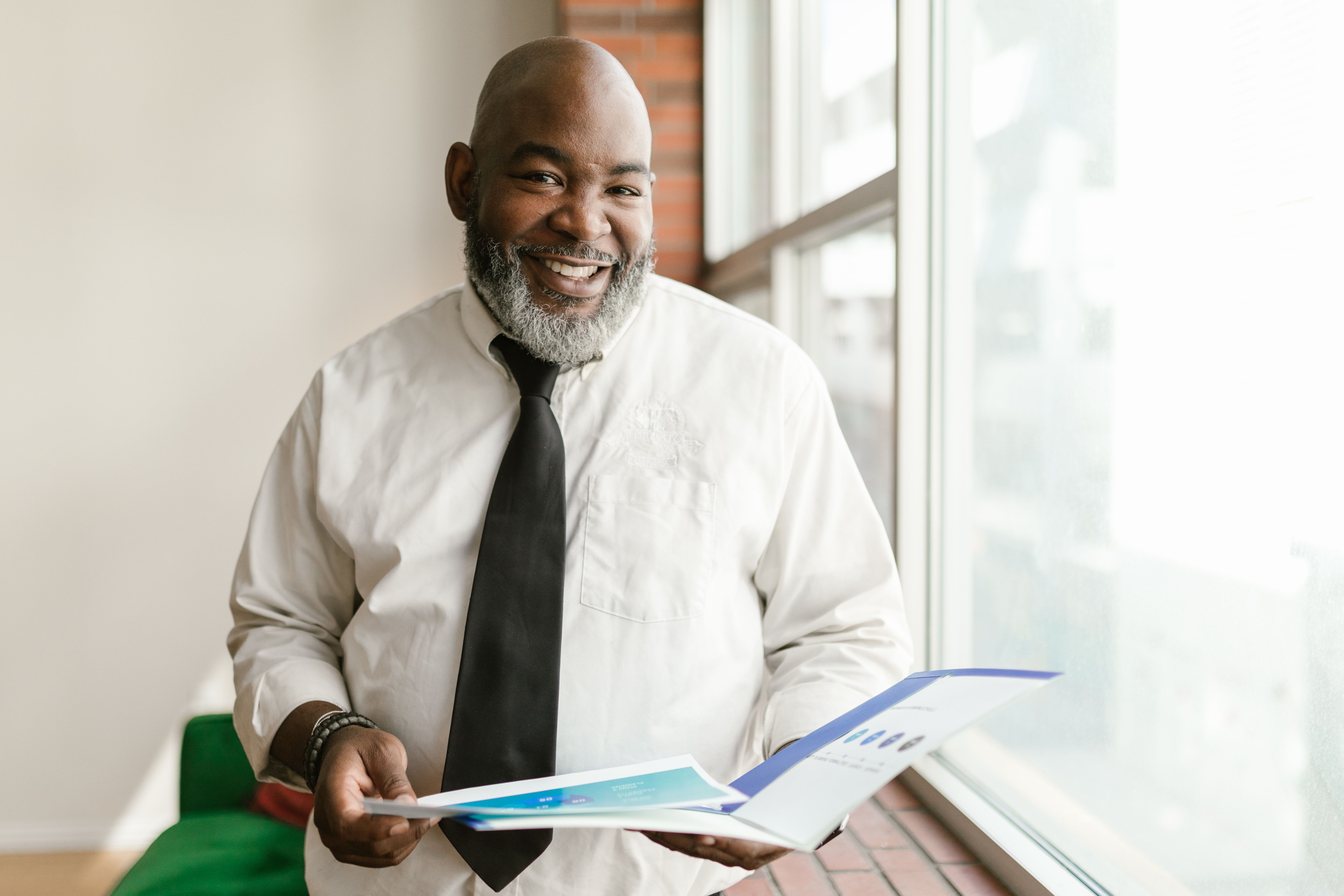 A Kenyan landlord reviewing a building report by the window