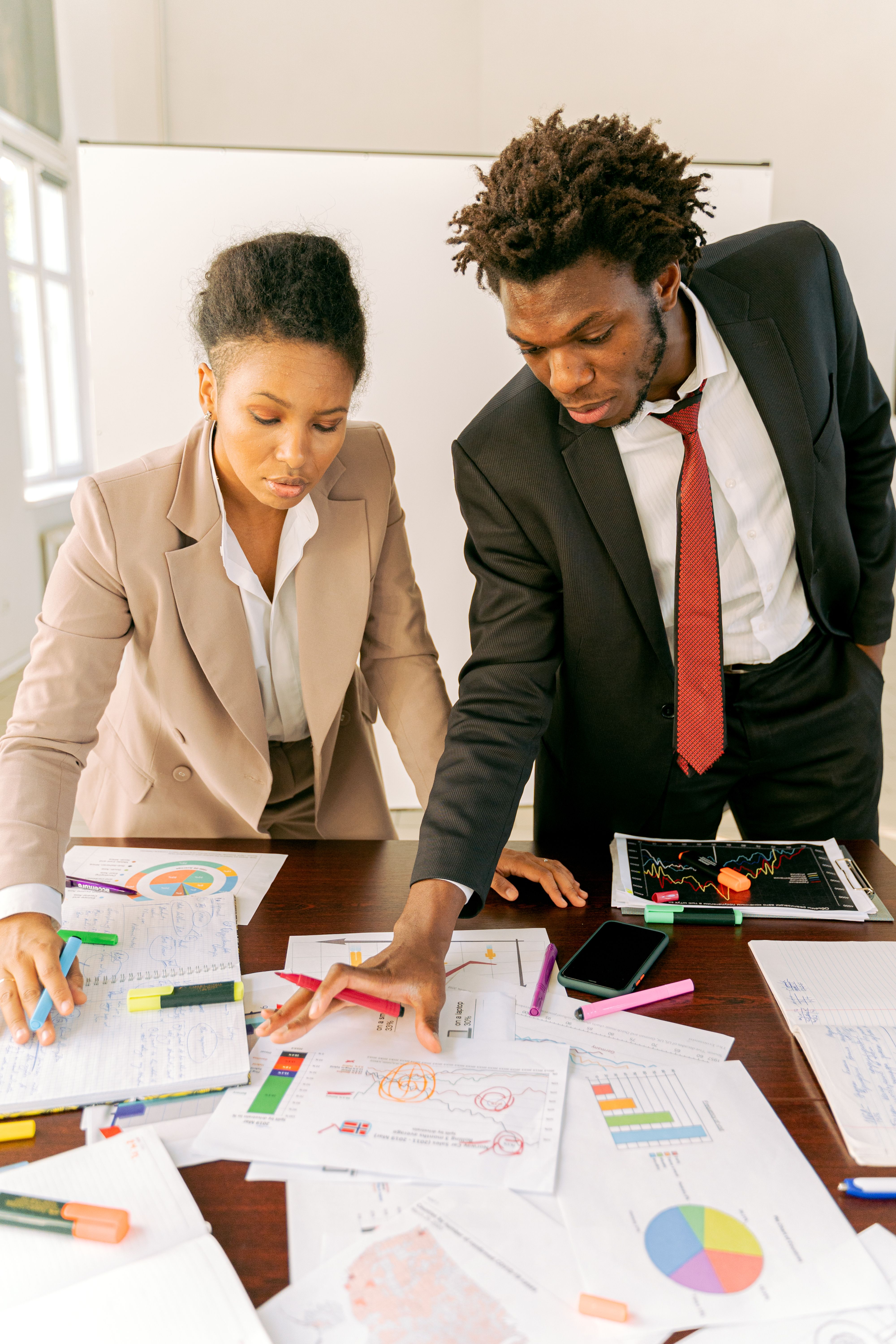Two property managers reviewing rent-roll and arrears reports together